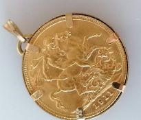A George V gold full sovereign in a 9ct gold mount, 8.78g