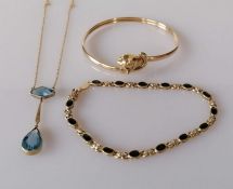 A gold bangle with fox head terminal and garnet decoration to eyes; a gold bracelet with oval sapphi