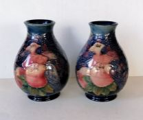 A pair of Moorcroft 'Finches' pattern vases tubelined with the birds against a dark blue ground, imp