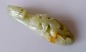 A 19th century Chinese jade belt buckle hook with dragon head carving and chilong surmount to shaft,