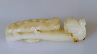 A 19th century Chinese white jade belt buckle hook with carved dragon head and chilong surmount to