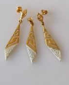 A yellow and white gold pendant with pierced Greek-key design and diamond decoration with a pair