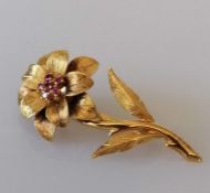 A ruby-set flower brooch in 18ct yellow gold, with six round-cut rubies to the centre