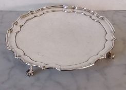 A QEII silver salver with pie crust border on four scrolled feet by Roberts & Dore Ltd., Birmingham,