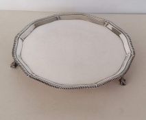 A hexagonal George VI silver salver with moulded rim on claw and ball feet