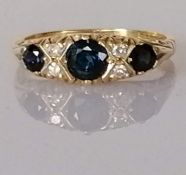 A graduated three-stone sapphire and diamond ring on a carved 18ct yellow gold setting