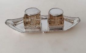 An Edwardian silver inkstand with twin glass inkwells, carved decoration to rims and hobnailed bases