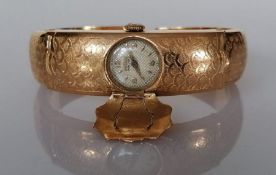 A vintage gold bangle with Imperios watch mechanism and articulated arms, 27.8g