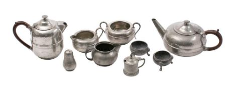 A beaten pewter four-piece tea set, includes a tea pot, hot water jug, cream jug and sugar basin,