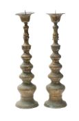 A pair of large brass pricket candlesticks with inverted bell-shaped sconces,