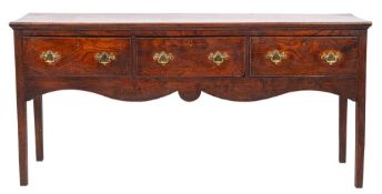 A George II elm dresser, mid 18th century; the single piece top with moulded edges,
