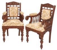 A pair of Anglo Indian or Burmese carved hardwood open elbow chairs,