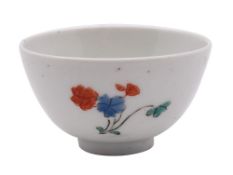 A small Japanese teabowl possibly Hizen ware, decorated in the kakiemon palette with floral sprays,