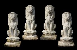 A set of four white painted reconstituted stone garden models of lions,