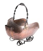A beaten copper and wrought iron coal scuttle of barge-shaped outline,