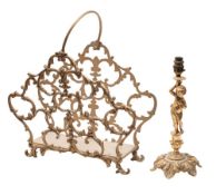 A gilt metal magazine rack of arched outline, with loop carrying handle, raised on scroll feet,