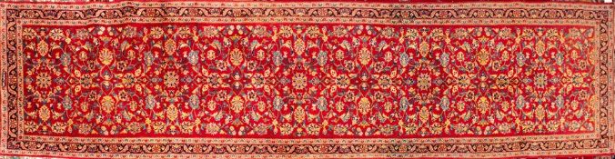 A Kashan runner, the red field with an all over geometric design of palmettes,
