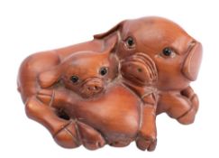 A Japanese boxwood netsuke in the form of a sow and piglet,
