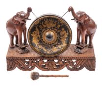 An Anglo-Burmese carved and stained hardwood and metal mounted dinner or hall gong,