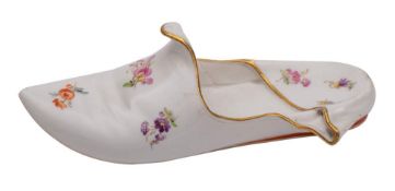 A Meissen porcelain model of a slipper painted with scattered floral sprigs and orange heel within