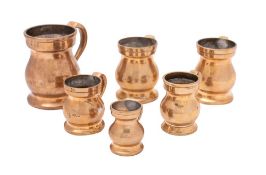 A collection of six assorted bronze measures with scroll handles, various sizes.