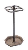 A Victorian cast iron stick stand with four circular divisions on a tapering stem raised on an