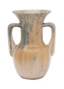 A Ruskin two-handled vase with flared rim, covered in a pale yellow,
