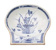 A Chinese blue and white shell-shaped dish painted with lotus within a diaper border, Qianlong,
