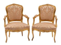 A pair of carved and giltwood and silk damask upholstered fauteuils in Louis XV style,