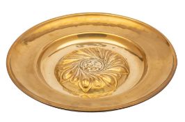 A Nuremberg brass alms dish with central raised foliate swirled boss with lion rampant to the