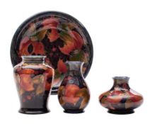 Three Moorcroft vases and a plate each tube lined in the Pomegranate pattern in red, purple,