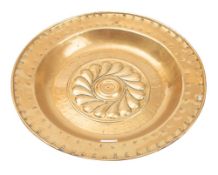 An 18th century Nuremberg brass alms dish of traditional design with central gadrooned boss,