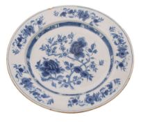 A Dutch delft charger, painted in blue with peony and prunus with further blooms on the border,