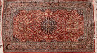 A Qum silk rug, the red field with a design of animals, palmettes and floral foliage,