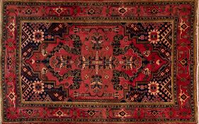 A Heriz carpet, the rose geometric field with a central cruciform medallion,