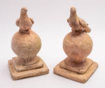 A pair of late 19th/early 20th century terracotta roof finials in the form of a dove resting on a