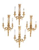 A set of four gilt-metal twin branch wall appliques with ribbon tied floral spray decorated