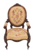 A Victorian carved walnut and Berlin tapestrywork upholstered arm chair,