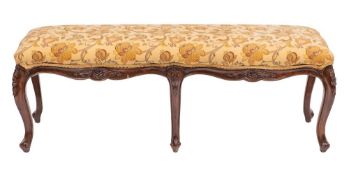 A walnut and upholstered long stool or window seat in George III style,