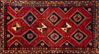 A Lori Rug, the brick red field with a design of hooked and stepped lozenge medallions,