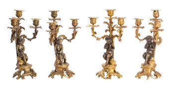 Two pairs of 19th century bronze and gilt metal three branch candelabra with foliate decorated