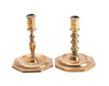 An 18th century brass candlestick with plain cylindrical sconce on a knopped and tapering stem