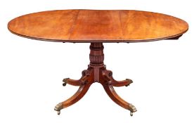 A Regency mahogany extending dining table, early 19th century; the oval top with one extra leaf,