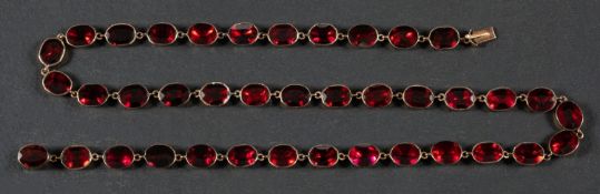 An early 19th century, oval, flat-cut, garnet, rivière necklace, with foil and closed-back,