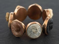 A Georgian, carved lavastone cameo ring, with the carved cameo heads depicting the days of the week,