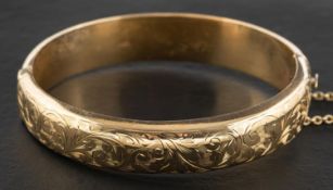 A 9ct gold hinged bangle with foliate engraving, with hallmarks for Chester, 1956,