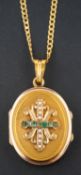 An emerald and seed pearl oval, locket pendant, with fleur-de-lys design to front,