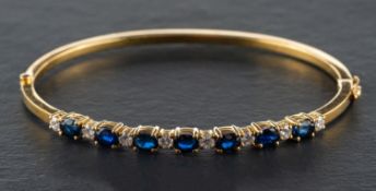 An oval, mixed-cut sapphire and round, brilliant-cut diamond hinged bangle,