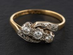 A single and round, brilliant-cut diamond cross-over ring,