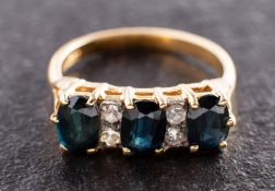An oval, mixed-cut sapphire three-stone ring, with single-cut diamond spacers,